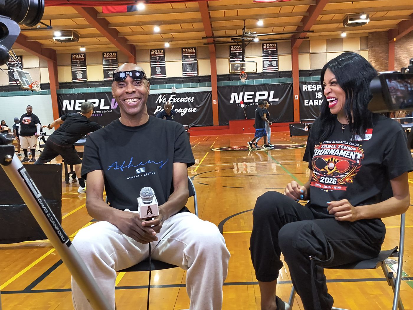 K-Rino conducting a courtside interview with a Legends 34 branded microphone flag.